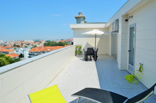 a balcony with a table and chairs and an umbrella at Musical View in Porto