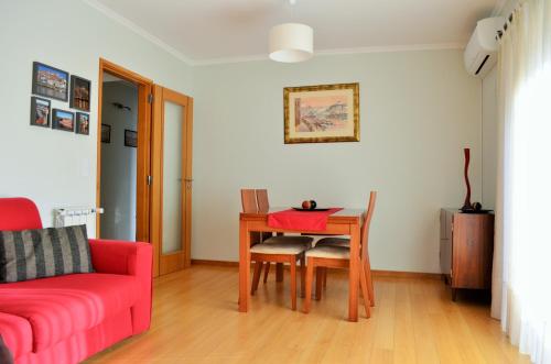 a living room with a table and a red couch at Musical View in Porto