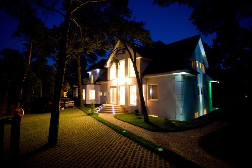 a house with lights on the side of it at night at Morska Fala in Pobierowo