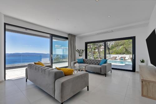a living room with two couches and large windows at Villa Melody in Bast