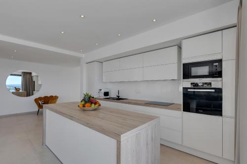 a kitchen with white cabinets and a wooden counter top at Villa Melody in Bast