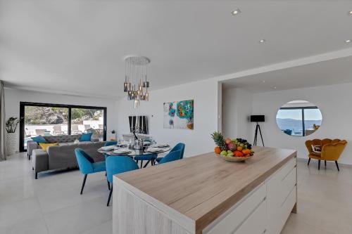 a kitchen and living room with a table and chairs at Villa Melody in Bast