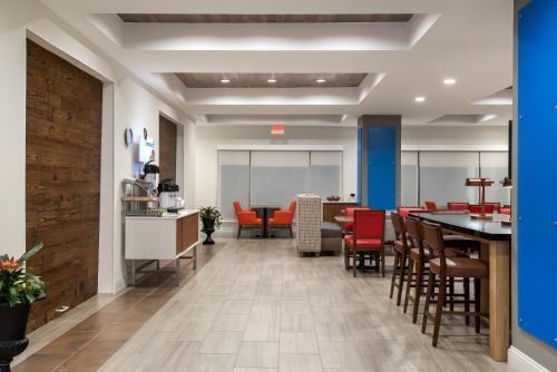 an office lobby with a dining area with red chairs at Holiday Inn Express & Suites Florence I-95 & I-20 Civic Ctr by IHG in Florence