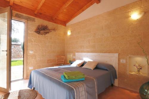 a bedroom with a bed and a large window at Tenuta Serre in Salve