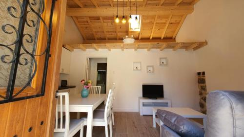 ein Esszimmer und ein Wohnzimmer mit einem Tisch und einem TV in der Unterkunft Casas del Castillo, 4 in Avila