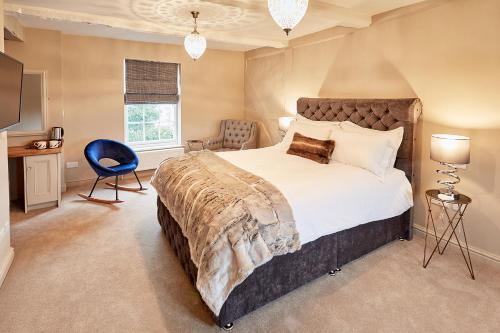 a bedroom with a large bed and a blue chair at The New Inn in Hereford