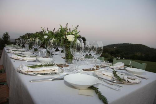 a long table with wine glasses and flowers on it at Tenuta Seripa in Sassetta