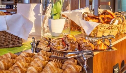 a table with a bunch of pastries and baskets of bread at Crowne Plaza Frankfurt Congress Hotel by IHG in Frankfurt/Main