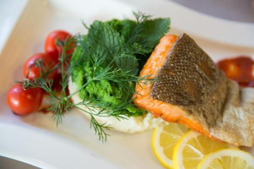 a plate of food with a piece of fish and vegetables at Crowne Plaza Frankfurt Congress Hotel by IHG in Frankfurt/Main