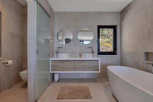 a bathroom with a tub and a sink and mirror at Villa Melody in Bast