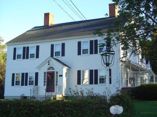 a white house with black shutters and a porch at Stephen Clay Homestead Bed and Breakfast in Candia