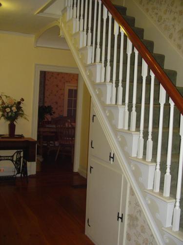 a white staircase in a home with a stair case at Stephen Clay Homestead Bed and Breakfast in Candia
