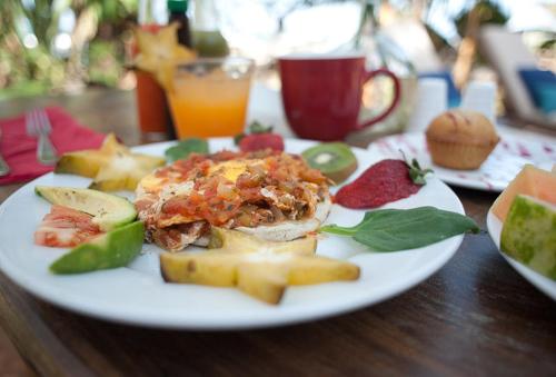 a white plate of food on a wooden table at Sueño del Mar Beachfront Hotel in Tamarindo