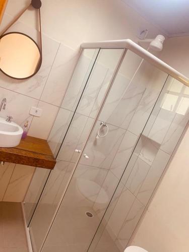 a glass shower in a bathroom with a sink at Chales em Salesopolis - Recanto da Barra in Salesópolis