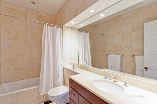 a bathroom with a sink and a toilet and a mirror at Historic luxury Townhouse in Downtown Chicago in Chicago