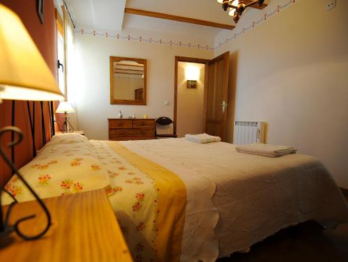 a bedroom with a large bed with a yellow blanket at Apartamentos Rurales San Juan in Castellnovo