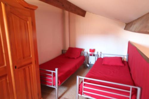 - 2 lits dans une petite chambre avec des draps rouges dans l'établissement Jolie maison d'angle, pour 4 couchages, terrasse, résidence piscine commune à 400m plage de PORTIRAGNES PLAGE LRJP134, à Portiragnes