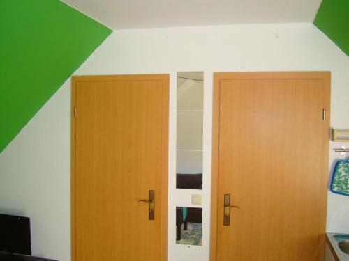 two wooden doors in a room with a green ceiling at Fewo-Rammenau Monteurunterkunft in Rammenau
