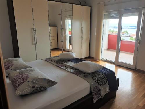 a bedroom with two beds and a large window at Stella Maris in Kaštela
