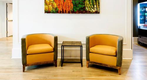two chairs and a table in a room with a painting at Hotel Indigo Savannah Historic District by IHG in Savannah