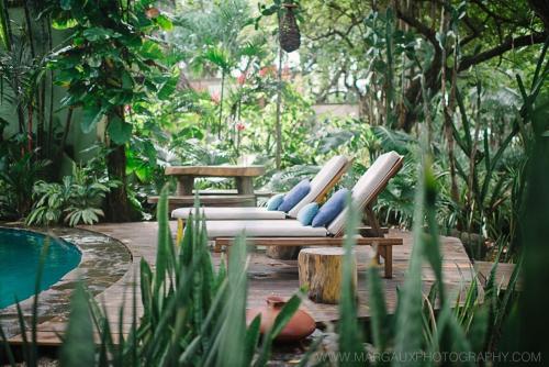 a patio with two lounge chairs and a pool at Sueño del Mar Beachfront Hotel in Tamarindo