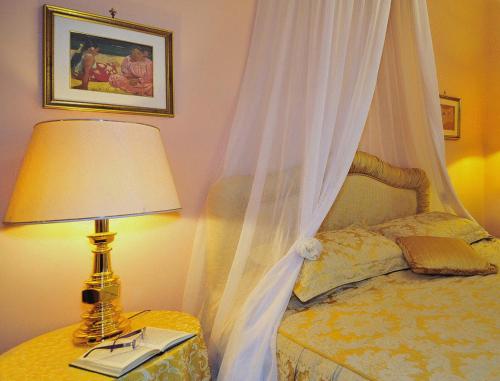 a bedroom with a bed with a canopy and a lamp at Villa Belvedere in Pieve Fosciana