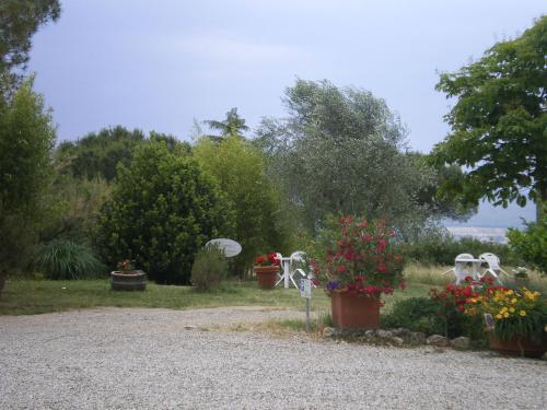 a garden with flowers in pots and white chairs at Fullino Nero Rta - Residenza Turistico Alberghiera in Siena