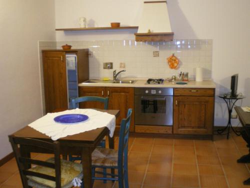 a kitchen with a table and a sink and a stove at Fullino Nero Rta - Residenza Turistico Alberghiera in Siena