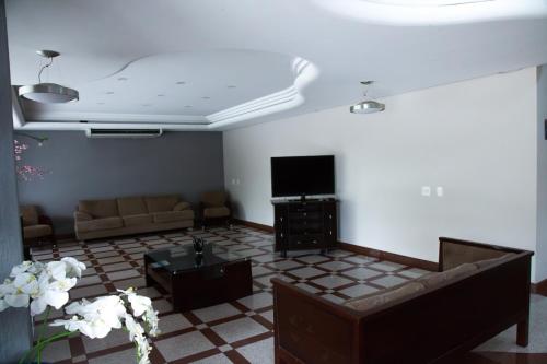 uma sala de estar com um sofá e uma televisão em Hotel Aquarius do Vale em São José dos Campos
