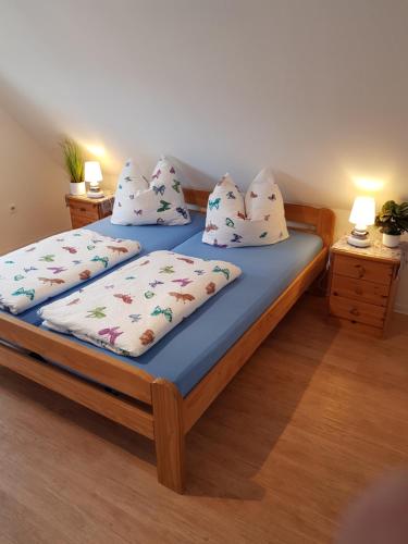 ein Schlafzimmer mit einem Bett mit Kissen darauf in der Unterkunft Haus Helgoland in Otterndorf bei Cuxhaven in Otterndorf