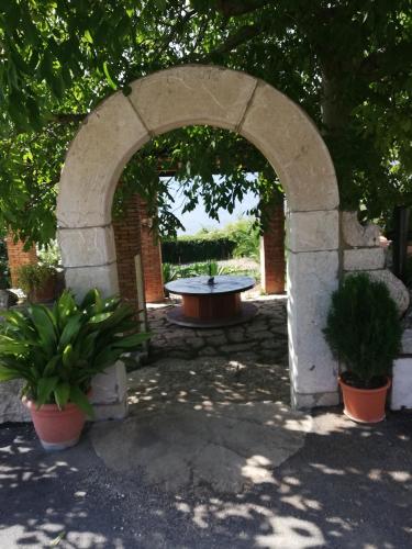 a stone archway with a table and some plants at Le Coste Affittacamere in San Lupo
