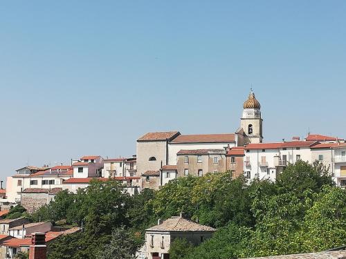 a building with a clock tower on top of a city at Le Coste Affittacamere in San Lupo