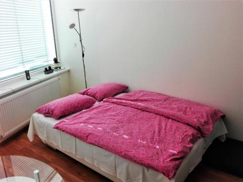 a bedroom with a bed with a pink blanket at New apartment with garage parking in Brno