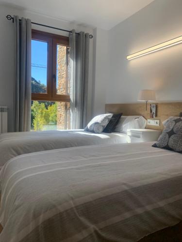 a bedroom with two beds and a window at Santa María de Panticosa in Panticosa
