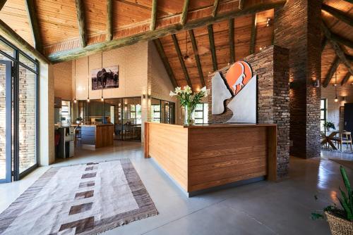 a lobby with a brick wall and a reception desk at Glen Harry Game Reserve in Graaff-Reinet