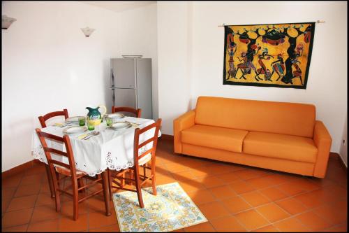 a dining room with a table and a couch at Orange Garden in Minturno