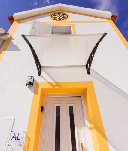 a white and yellow building with a door at Casinha da Encosta in Alenquer