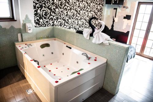 a bath tub in a bathroom with a black and white wallpaper at Posada la Leyenda in Santillana del Mar