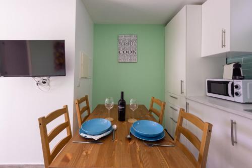 a dining room table with blue plates and wine glasses at Casinha da Encosta in Alenquer