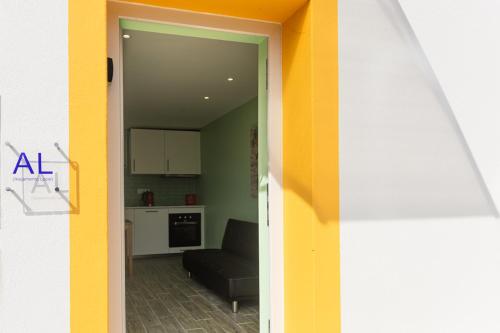 a living room with a couch and a kitchen at Casinha da Encosta in Alenquer