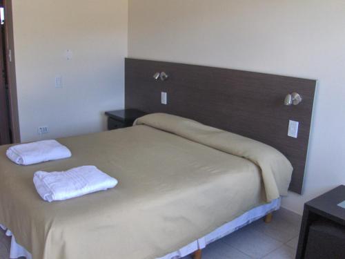 a bedroom with a bed with two towels on it at Kau Si Aike in El Chalten