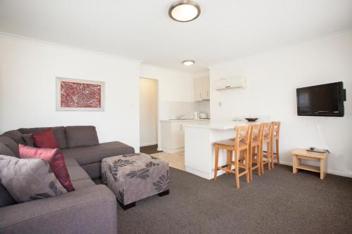 a living room filled with furniture and a tv at Centralpoint Motel in Wagga Wagga