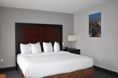 a bedroom with a large bed with white sheets and pillows at Wingate by Wyndham Atlanta Galleria/ Ballpark in Atlanta