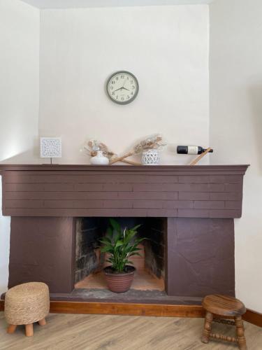 a fireplace with a clock on a white wall at Apartamento Completo en el centro de Durazno in Durazno