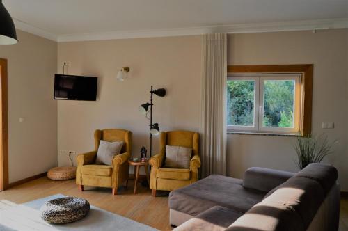 sala de estar con sofá y 2 sillas en Villam Natura & Spa en Vila Nova de Famalicão