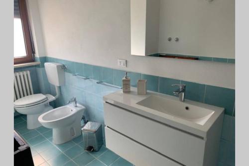 ein Badezimmer mit einem weißen Waschbecken und einem WC in der Unterkunft A CASA DI SISSI in Biella