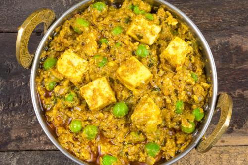 a pan full of food with tofu and peas at Hotel Aashiyana in Kāhārpāra