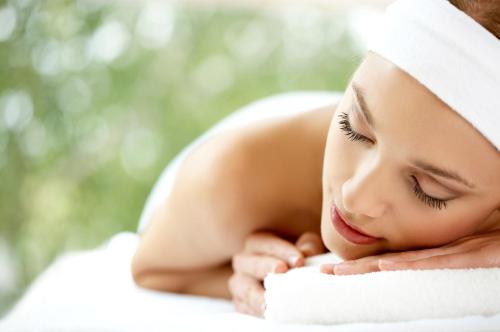 a young woman laying on a towel at Kimi Ora Eco Resort in Kaiteriteri