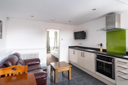 ein Wohnzimmer mit einem Sofa und einer Küche in der Unterkunft H.V Apartments in Sheffield
