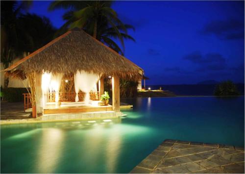 a resort with a swimming pool at night at Sutra Beach Resort, Terengganu in Batu Rakit